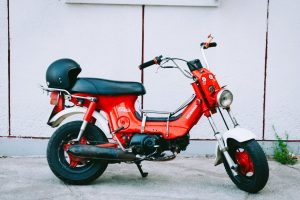 Classic red Honda Chaly motorbike parked against a wall in Vietnam.